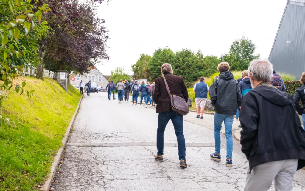 Une vingtaine de personnes, jeunes et moins jeunes, qui remontent une rue villageoise
