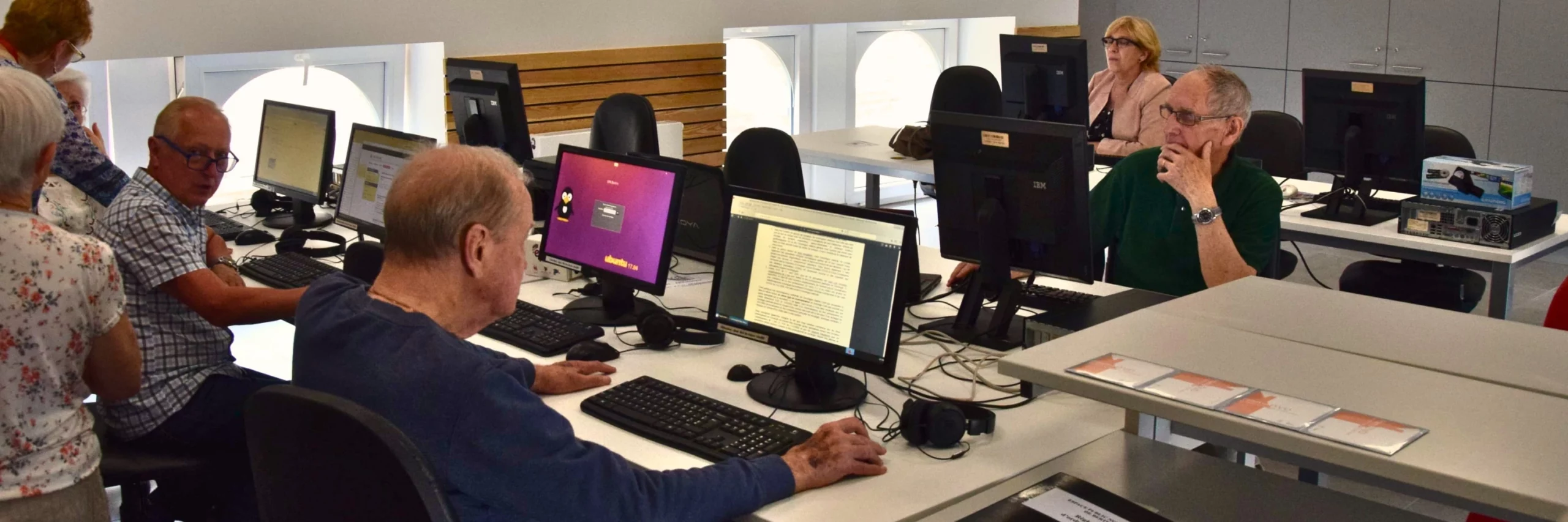 Des personnes âgées qui utilisent des ordinateurs dans un espace public numérique.