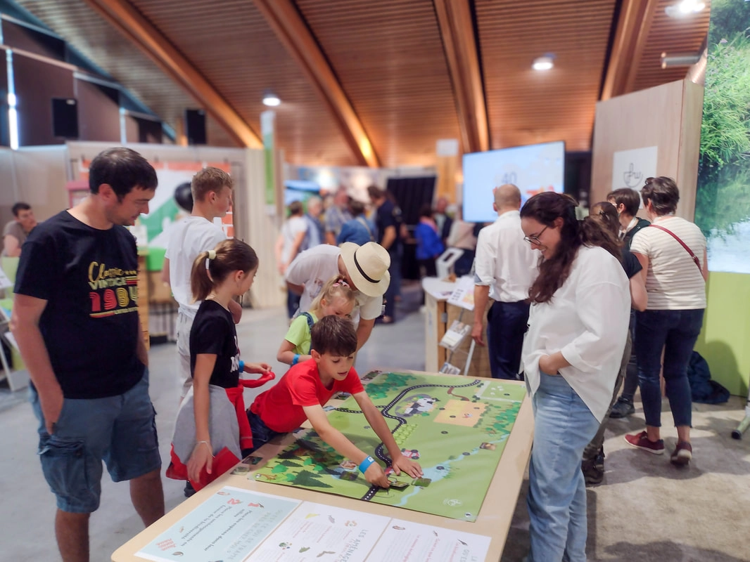 Des enfants découvrant le jeu "Qu'est-ce qui se trame près de chez moi ?" sur les trames écologiques lors de la foire de Libramont.
